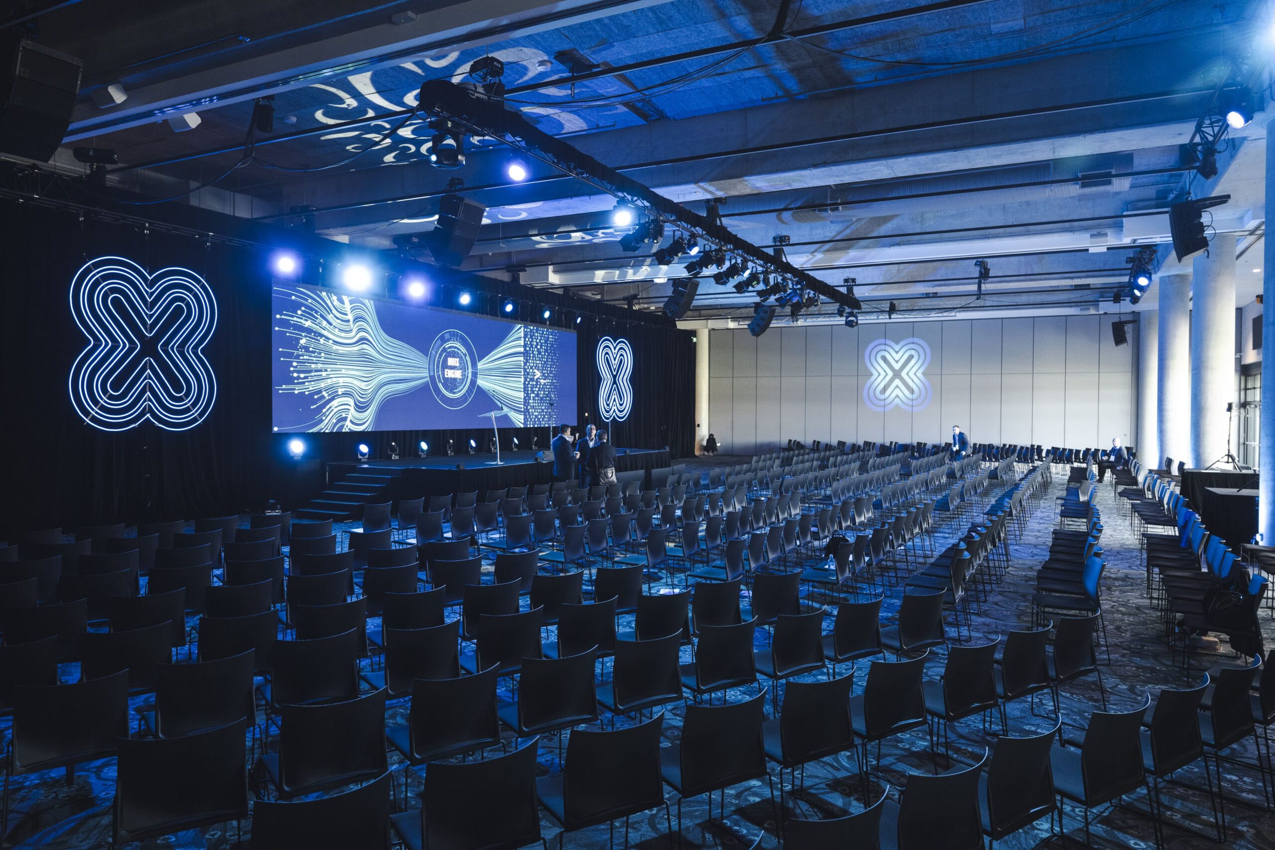 An empty function space with graphics shown on screen and projected onto walls